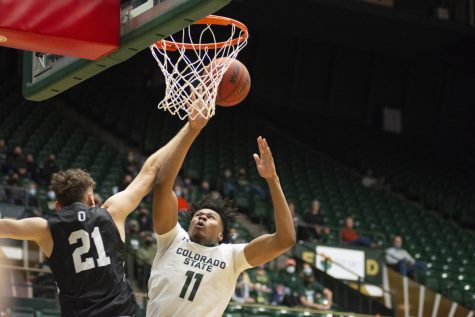 Colorado State foward Dischon Thomas (11) gets fouled by Adams State forward Hayden Meakes (21) on a layup Oct. 31. The Rams won 92-55 against the visiting Grizzlies (Gregory James | The Collegian)