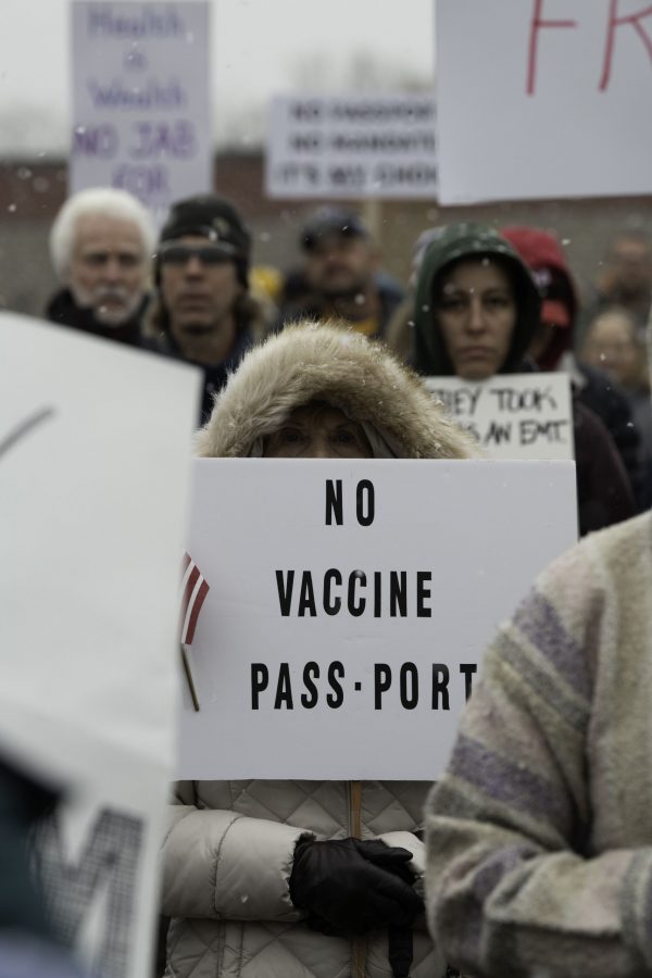 A woman stands in the snow holding a sing at a rally against vaccine mandates Nov. 1. The rally took place outside the Fort Collins Colorado public health office with approximately a one thousand five hundred attendees. (Garrett Mogel | The Collegian)