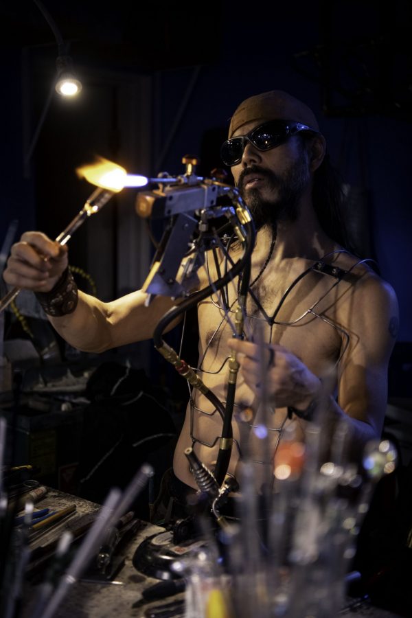 En-tao Andrew Hsu, artist name Torch Mouth tests a newly fabricated chest rig at Kind Creation Fort Collins Colorado Nov. 3. Torch Mouth stated "I'm half-assed good at a bunch of shit and wondered like what positioning I could get myself into." (Garrett Mogel | The Collegian)
