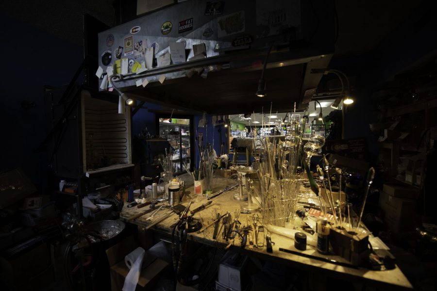The glass blowing workshop in the back of Kind Creations Smoke Shop in Fort Collins Nov. 3, 2021. The worktable sits below a fume hood with torches on each side of the table. Pipes, bongs, pendants and many other glass pieces are produced in the shop by several different artists.
