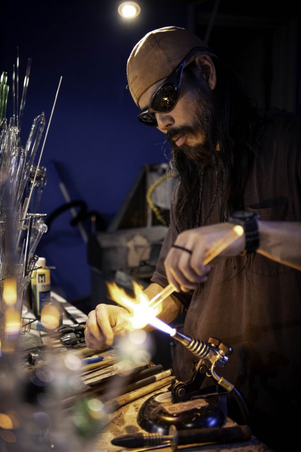 En-tao Andrew Hsu, artist name Torch Mouth practices a technique called coiling inside Kind Creation Fort Collins Colorado Nov. 3. Torch Mouth stated "I'm half-assed good at a bunch of shit and wondered like what positioning I could get myself into." (Garrett Mogel | The Collegian)