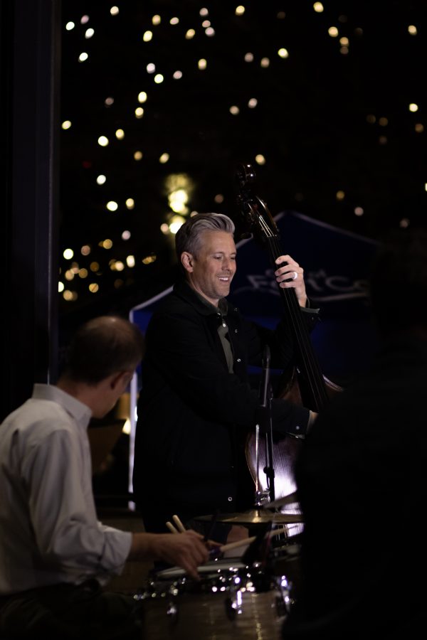 Todd Van Selus plays bass next to drummer Tobin Munsat in the live band Atom Collective for the Fort Collins, Old Town Square lighting ceremony Nov 5. (Grayson Reed | The Collegian)