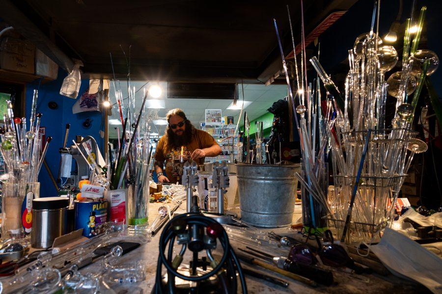 Skye Norton works in the Kind Creations glass blowing shop Nov. 9. Norton moved to Colorado and has been blowing glass for the past 20 years. (Milo Gladstein | The Collegian)