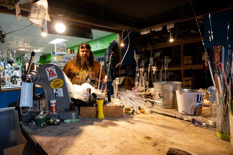 Sky Norton stands in the Kind Creations shop Nov. 9. Norton uses special welding goggles to protect his eyes. (Milo Gladstein | The Collegian)