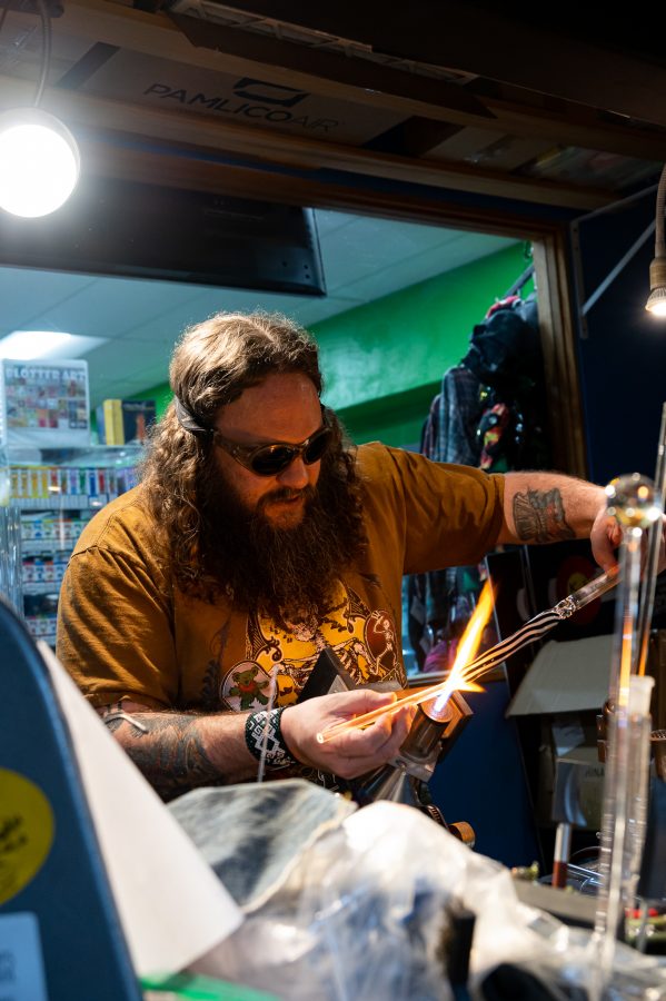 Skye Norton heats up a new piece at Kind Creations Nov. 9. When asked what the hardest thing to learn was Norton stated, "drawing, literally taking stringers and drawing on the back of a piece of glass." (Milo Gladstein | The Collegian)