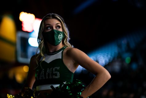 A member of the Colorado State University Golden Poms looks off towards the crowd.