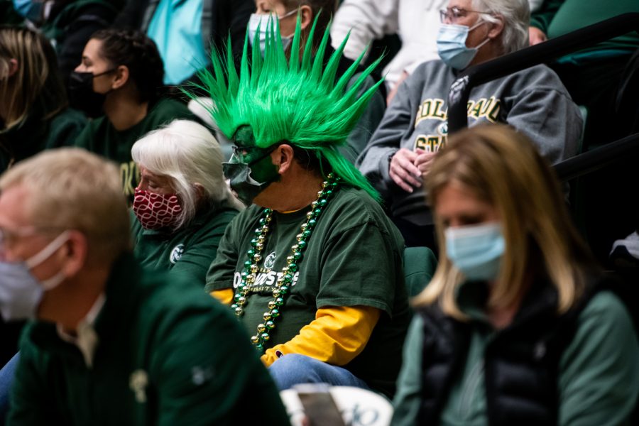 A Colorado State University fan with a giant green mohawk watches the game.