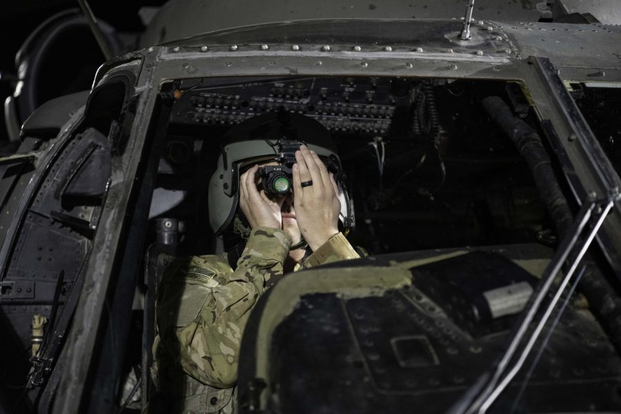 Pilot Chief Warrant Officer 2 Nathan Bosso of the 4th Combat Aviation Brigade prepares his night-vison goggles in the cockpit of a UH-60L Black Hawk before taking off from the Colorado State University Intermural Fields Nov. 13. CW2 Bosso stated, “The timing of everything. So after sunset it gets dark to ENT (Entry) where we can fly with our goggles about 48min after sunset. We could night unaided if we want but It is safer to fly with goggles.” The helicopter was requisitioned by the CSU Army ROTC to make an appearance for military appreciation day as well as CSUs football game against Air Force which resulted in a win for Air Force (35-21). (Garrett Mogel | The Collegian)