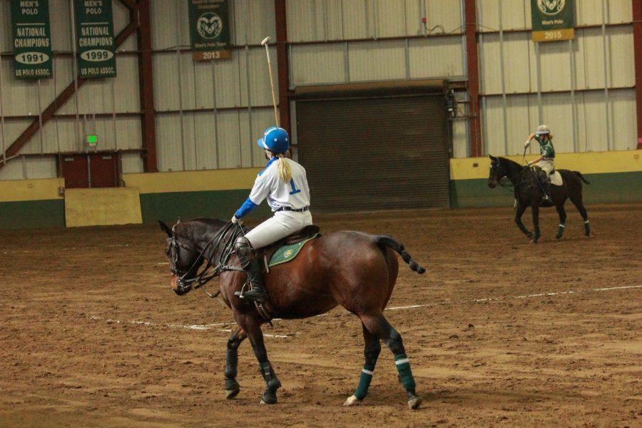 Player one on the opposing team warms up and gets used to her horse.