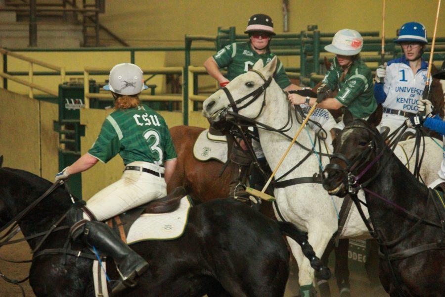 Riders on both teams push to try and get the ball.