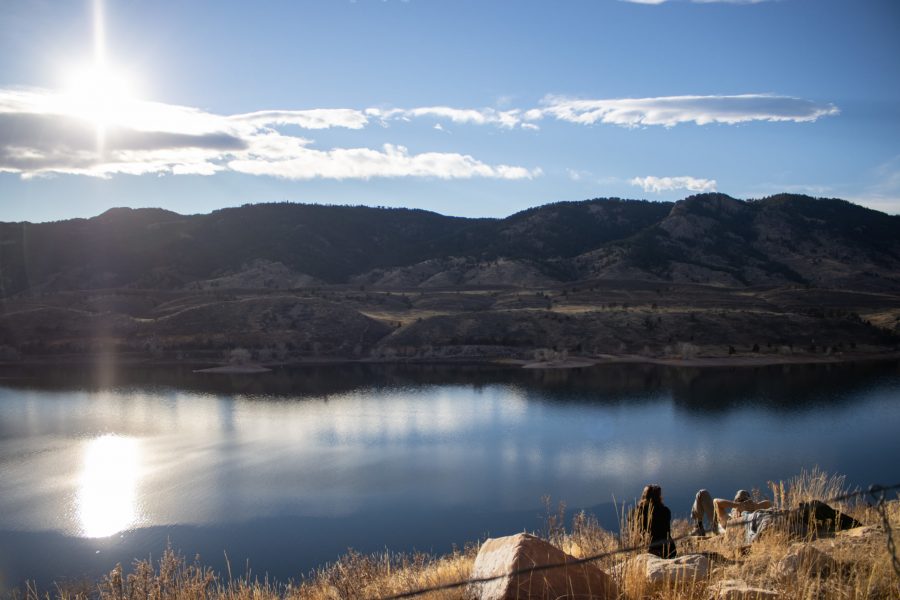Two people sit looking out over Horsetooth Reservoir