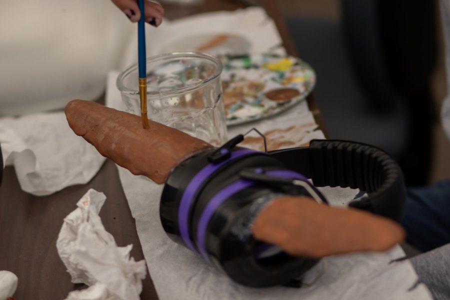 Connie Tibbits from Red Cloud Indian School paints a mold in the form of ears on modified headphones that when listening through mimic the directional sounds that animals hear Nov 20. The LSOP workshop taught and encouraged high school students to create experiments using simple household materials that show off their understandings of physics. (Grayson Reed |The Collegian)