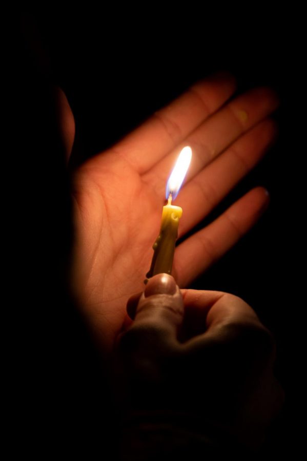 A participant holds a candle and celebrates the third night of Hanukkah in the Lory Student Center Plaza, Fort Collins Colorado Nov. 30. Joyce Mcconnell had the honor of lighting the menorah. (Milo Gladstein | The Collegian)
