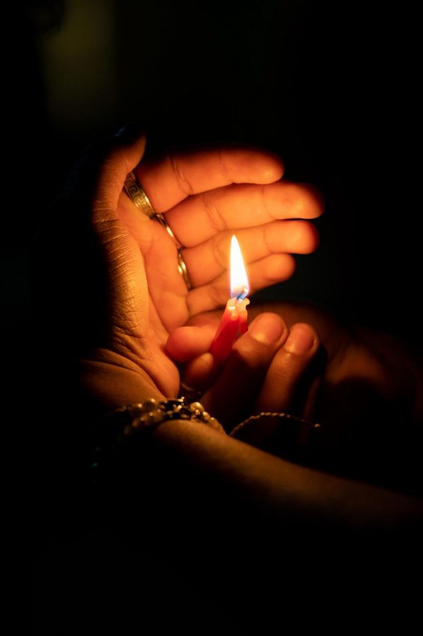 Participant holds a candle and celebrates the third night of Hanukkah in the Lory Student Center Plaza, Fort Collins Colorado Nov. 30. Joyce Mcconnell had the honor of lighting the menorah. (Milo Gladstein | The Collegian)