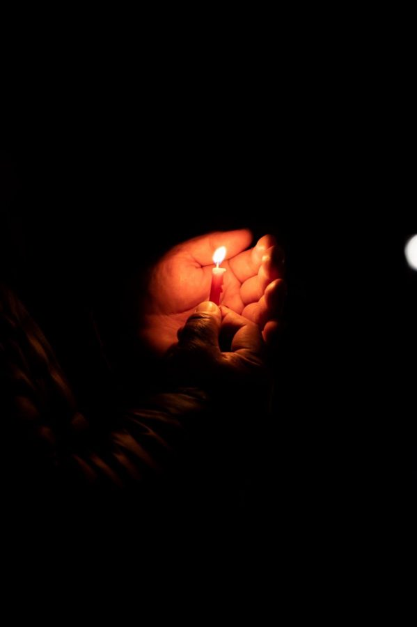 A participant holds a candle and celebrates the third night of Hanukkah in the Lory Student Center Plaza, Fort Collins Colorado Nov. 30. Joyce Mcconnell had the honor of lighting the menorah. (Milo Gladstein | The Collegian)