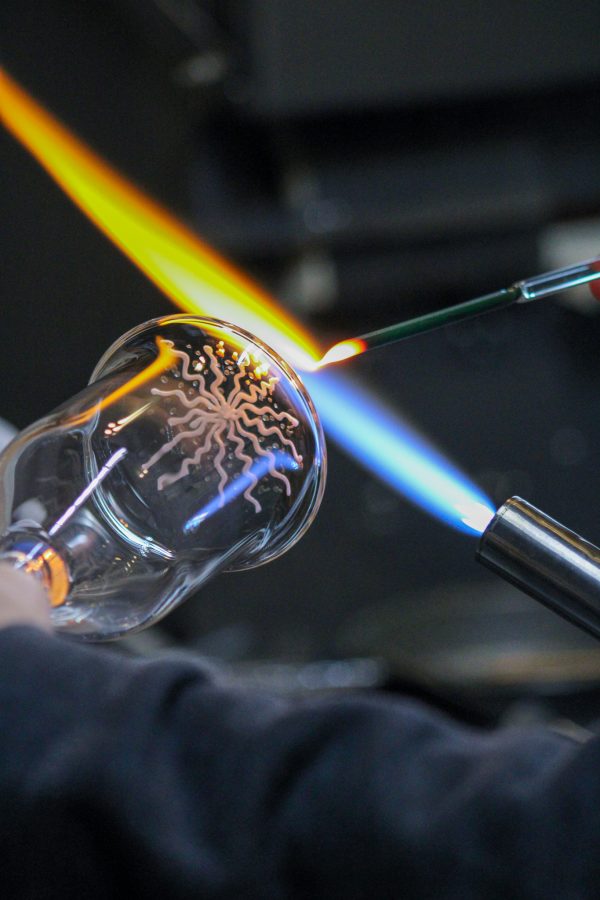 Bryan Ratcliffe, a local glass blower, creates the beginning of a mountain design in the bottom of a glass Nov. 2. Ratcliffe has an affinity for making drink ware. "I love making drink ware," Ratcliffe said. "I like making things that people use, that get conversations started."