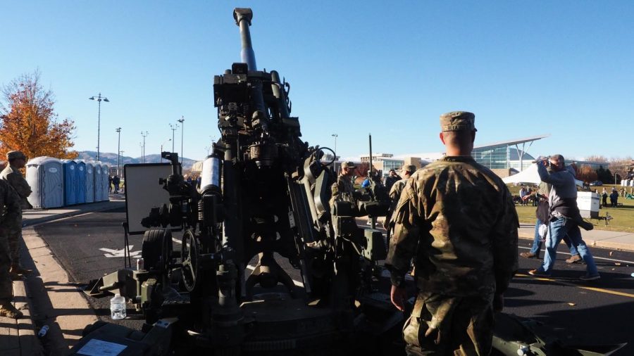 Private 2nd class Adrian Blea stands behind a AAA72 Howitzer canon parked along University Avenue Nov. 13.