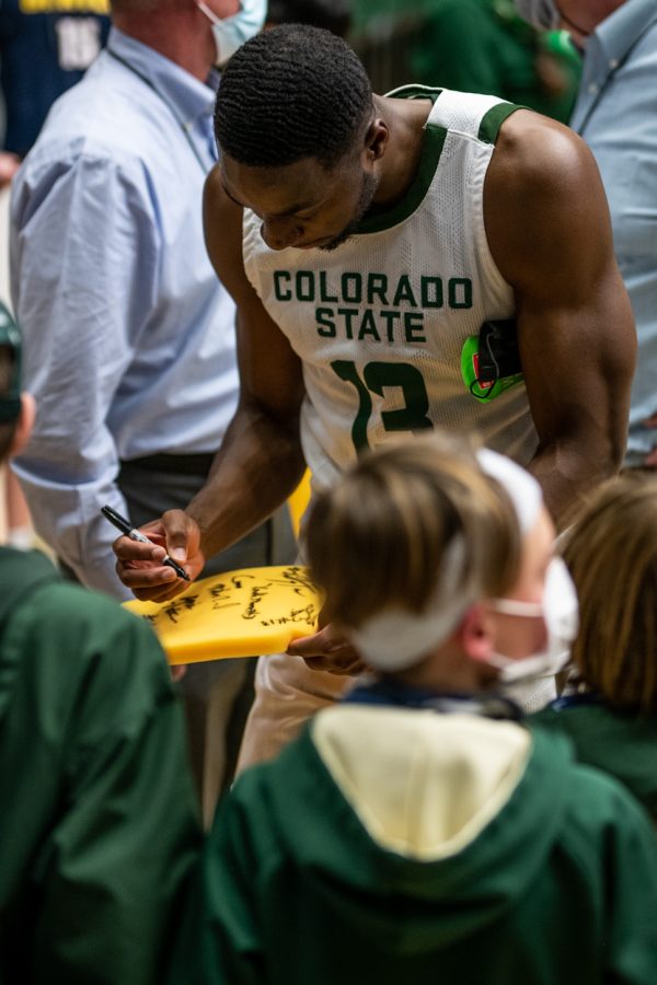 Before making it to the locker room after the final whistle was blown, fifth-year Chandler Jacobs (13) signs autographs on young fan’s foam-fingers