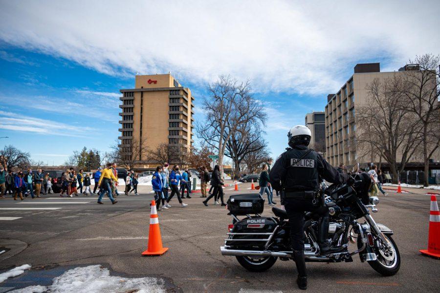 A Fort Collins police officer blocks off an intersecting street as participants in the Martin Luther King day celebration march down Howes Street in Fort Collins, CO Jan. 17.