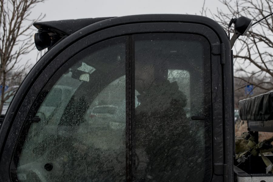 A Colorado State University staff member sits inside a vehicle with an attached brush to clear the icy sidewalks Jan. 19.