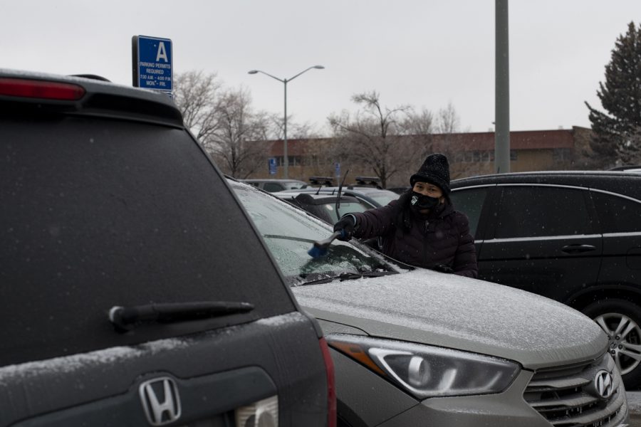 A woman scrapes the ice from her vehicles windshield outside Morgan Library on Colorado State Universities campus Jan. 19. Due to the Icy conditions across campus classes were canceled.