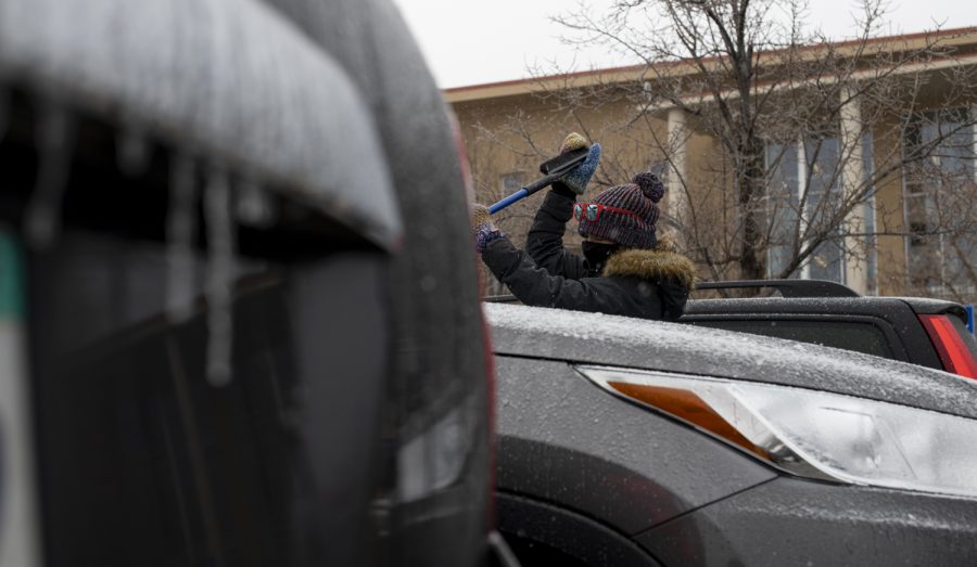 A woman scrapes the ice from her vehicles windshield outside Morgan Library on Colorado State Universities campus Jan. 19.