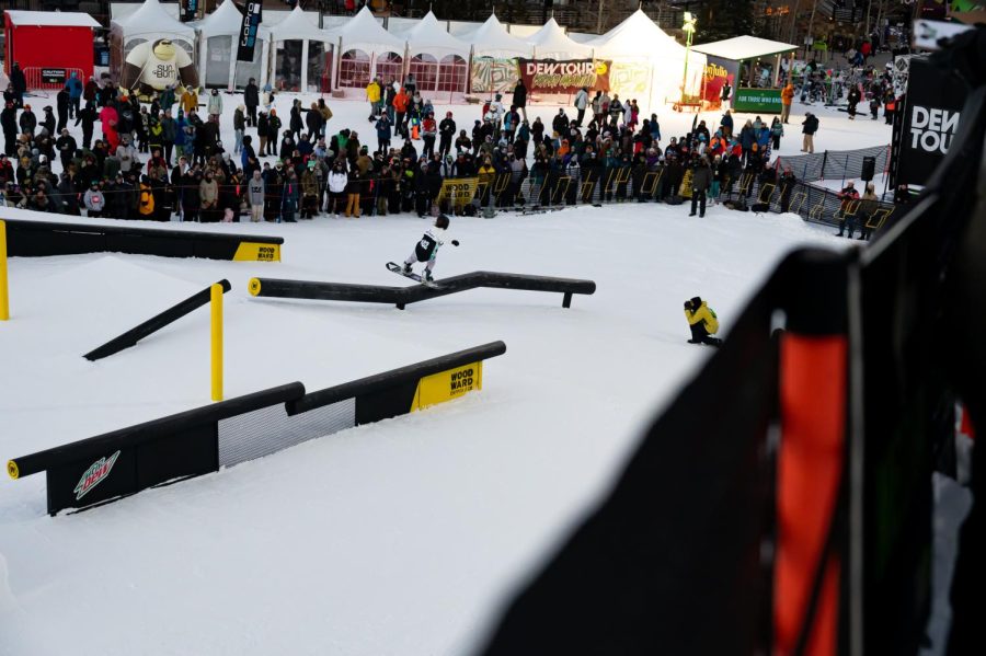 Nora Beck performs a boardslide in front of the crowd at women’s snowboard street style finals at Dew Tour