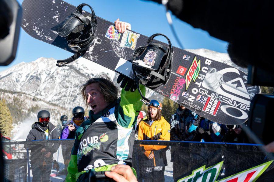 Red Gerard holds his board up in celebration after winning slopestyle finals at Dew Tour for the second year in a row