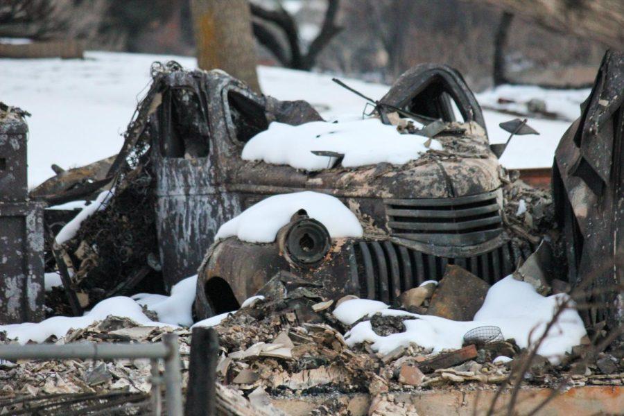 A Volkswagen beetle sits charred in the driveway of its former home.