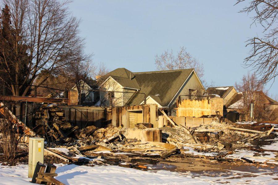 The remains of two houses sit in front of a few houses that were spared.