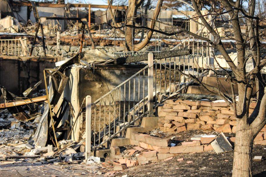 The railing of a staircase is still standing among the rubble.