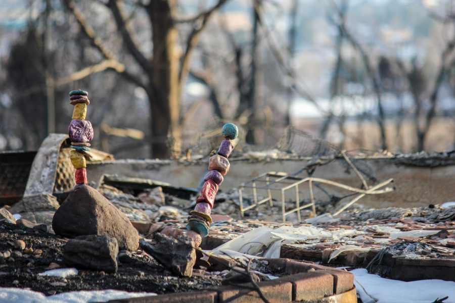 Colorful stone towers remain standing in the charred dirt and rubble.