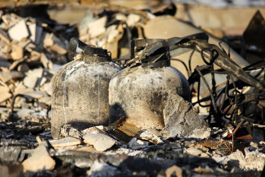 Two propane tanks sit among the rubble of a home.