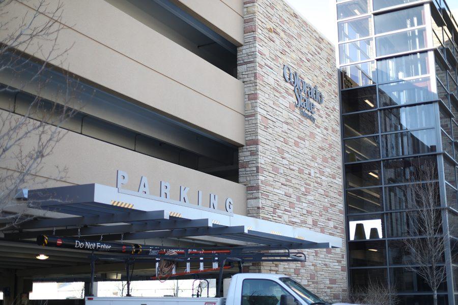 The outside entrance to a parking garage with a sign that says parking and a sign that says Colorado State University on the side of the building