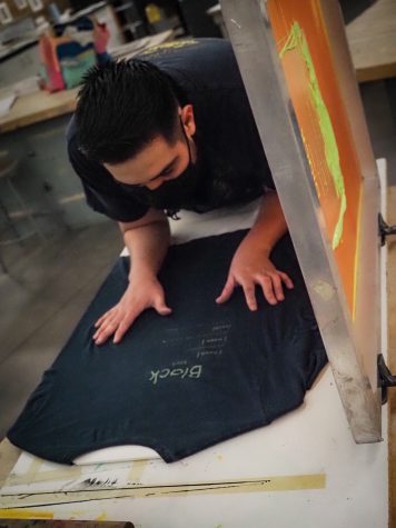 Vicente Delgado examining his t-shirt's imprint