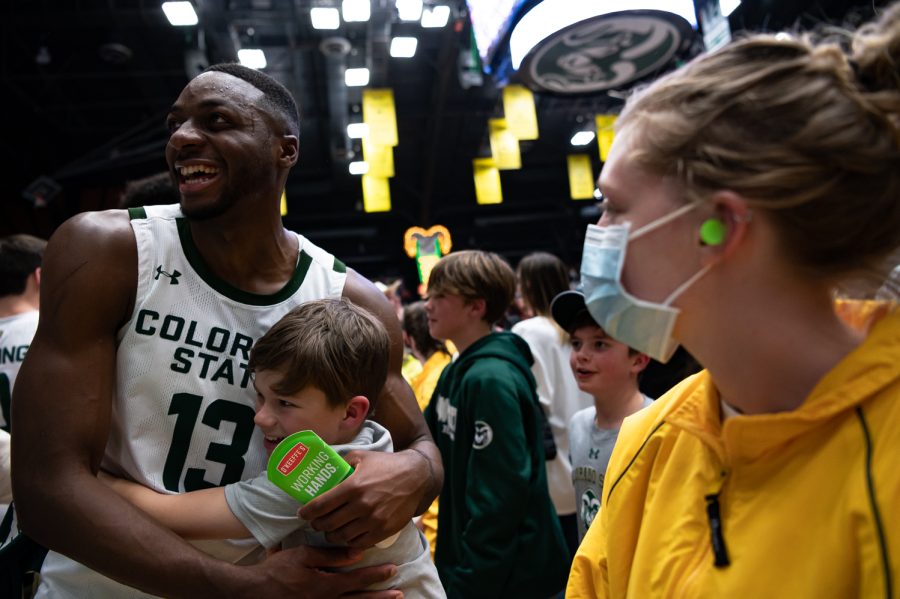 Chandler Jacobs (13) celebrates with a fan after the CSU basketball game vs University of Wyoming at Moby Arena