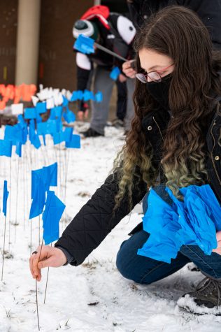 Sarah Daniel places flags in the ground outside the Lory Student Center at Colorado State University to memorialize Holocaust victims