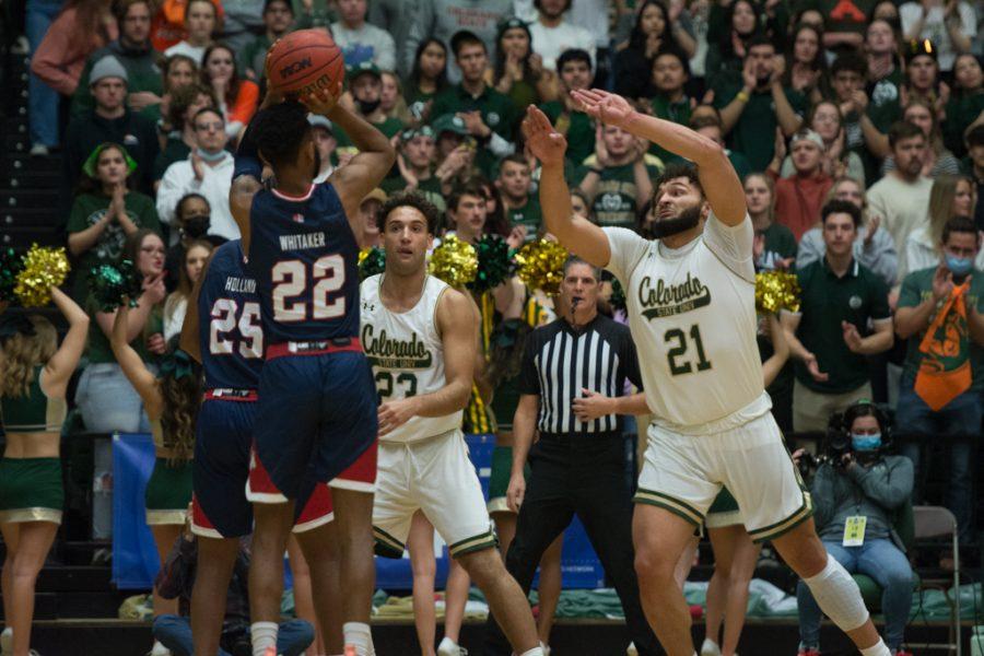 Colorado State guard David Roddy (21) reaches out to block a shot by California State University, Fresno guard Destin Whitaker (22) Feb. 11, 2022
