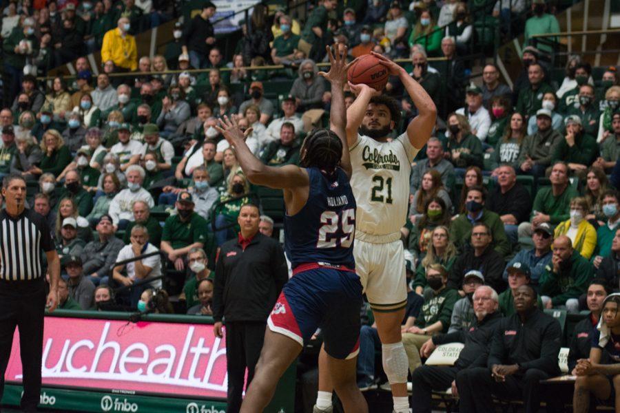 Colorado State guard David Roddy (21) shoots a three point shot as California State Universtiy Fresno guard Anthony Holland defends Feb. 11, 2022.