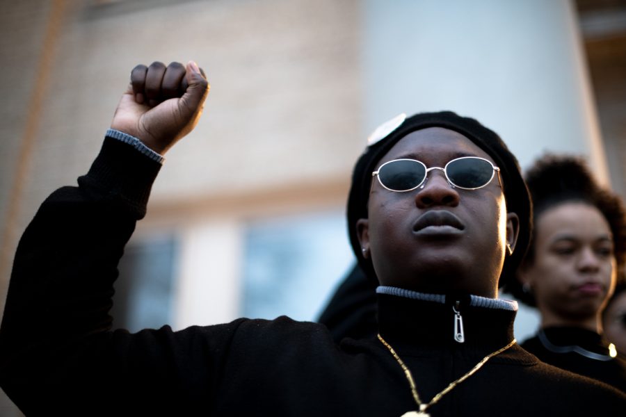 Joseph Adenowo holds up a fist during the Black Out event on The Oval Feb. 15. The event was meant to deconstruct the myths of the Black Panther Party and celebrate solidarity shown by the Black community.