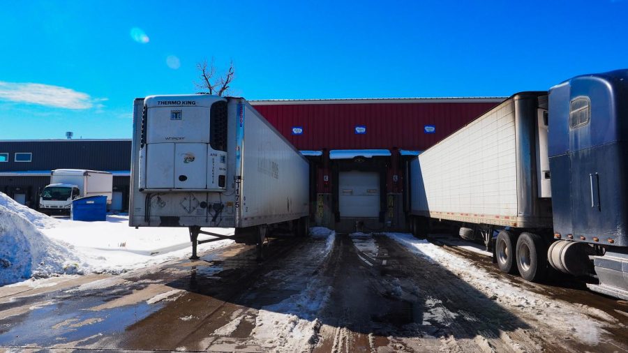 Delivery trucks park in a loading dock