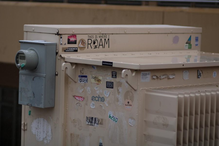 Stickers plaster an electrical box outside of the Clark A building.