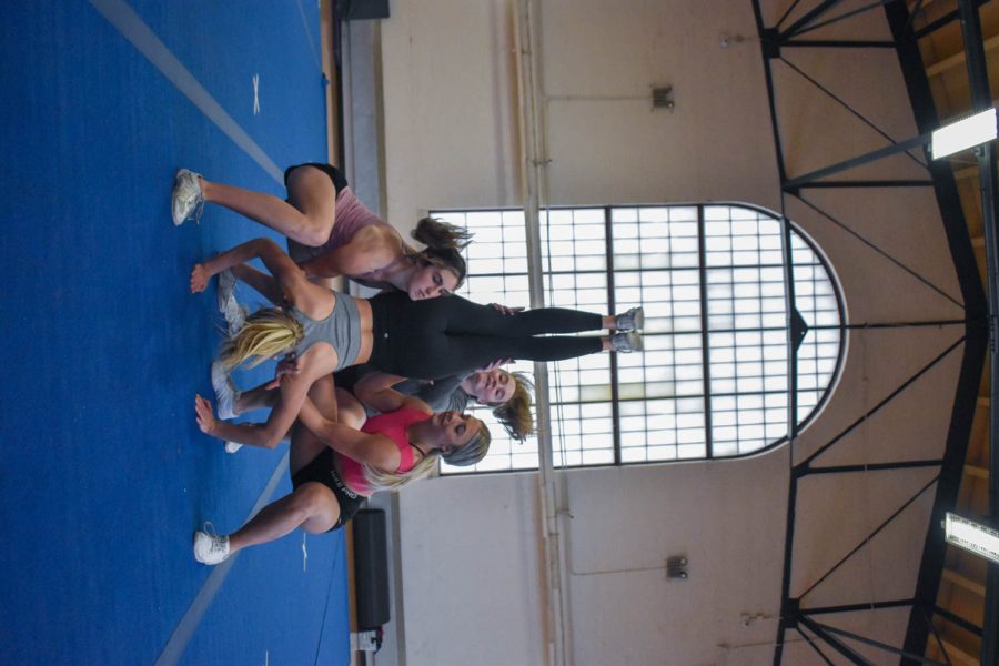 Colorado State University cheerleaders beginning a stunt during one of the final practices for seniors as they prepare to graduate in the spring.