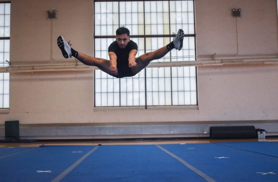 Juan Barreras, senior cheerleader at Colorado State University caught in the air as he finishes a toe-touch jump.