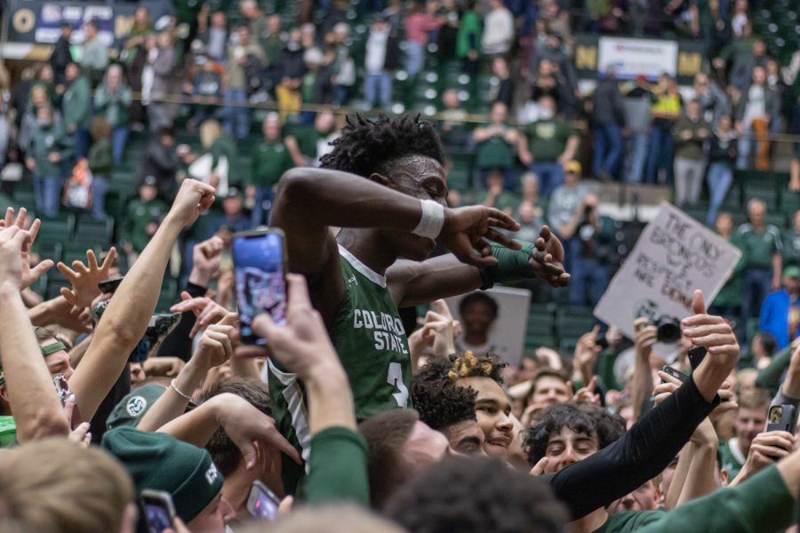 Fans hold up Colorado State Guard Kendle Moore (3)