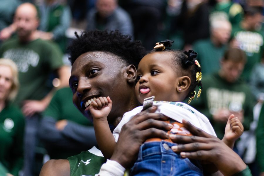 Colorado State Guard Kendle Moore (3) holds his daughter after a post game interview.