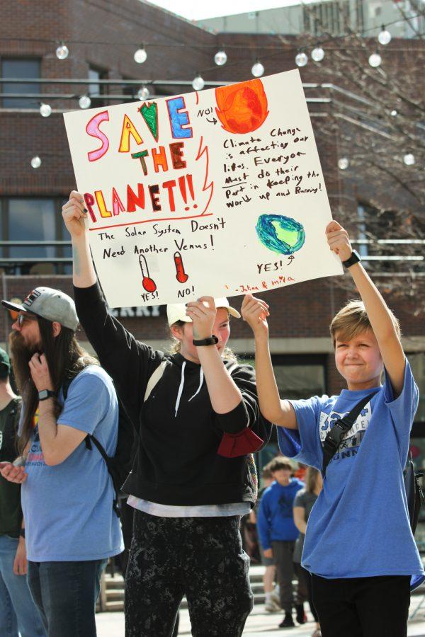 Two young participants hold up a poster during a climate strike in Fort Collins