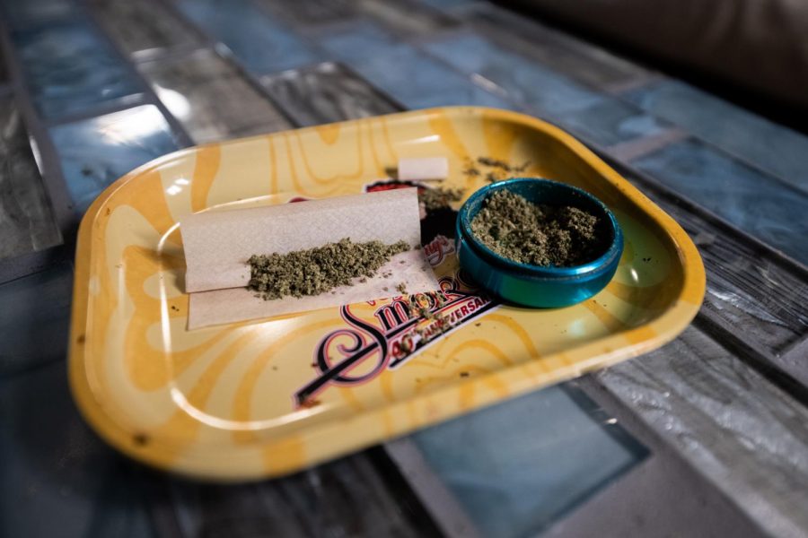 A joint sits filled with ground cannabis flower, waiting to be rolled and sealed