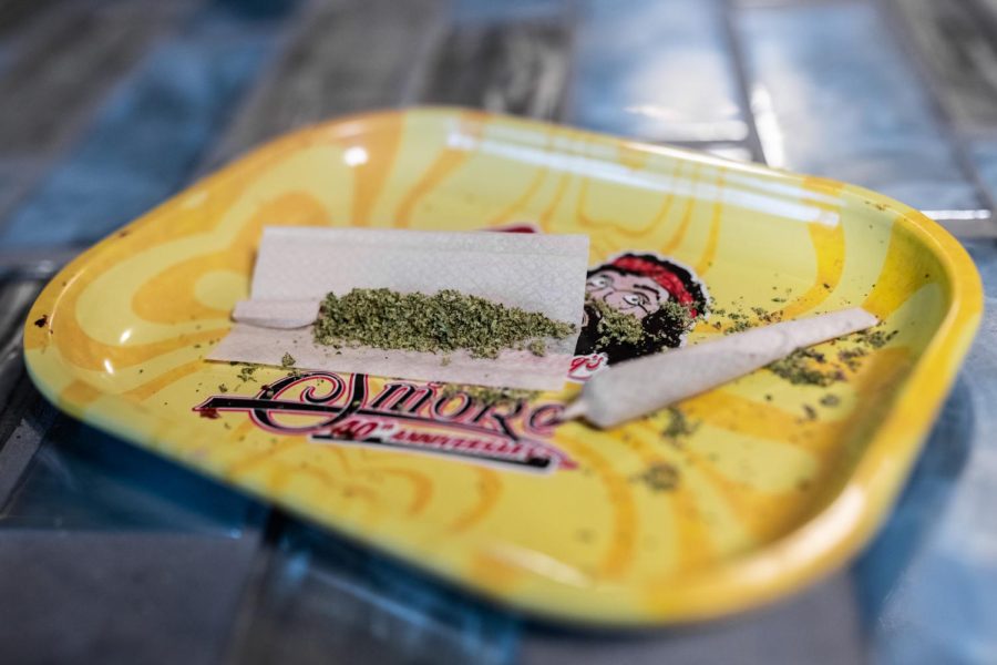 A joint sits filled with ground cannabis flower, waiting to be rolled and sealed