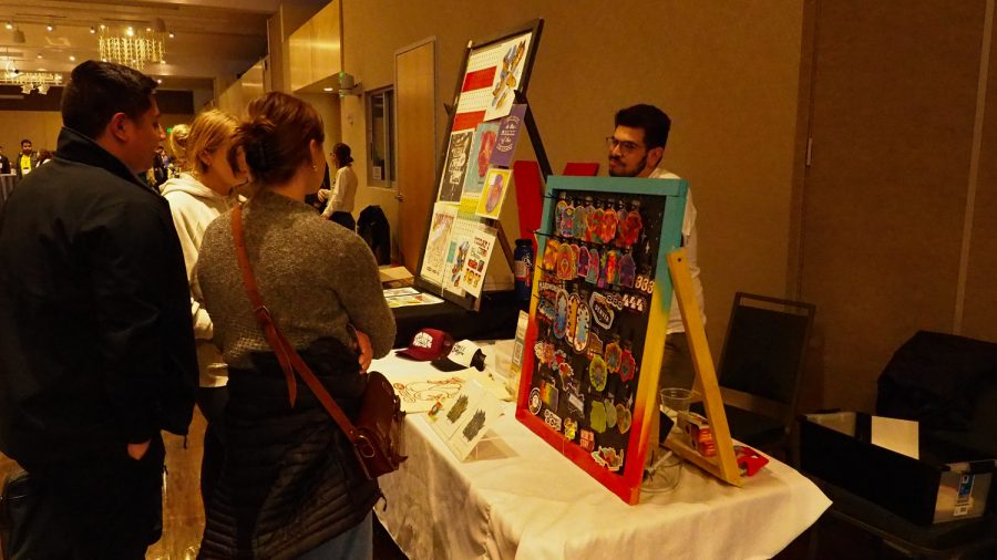 Brayan Montes sells stickers that he deigned in the Lory Student Center grand ballroom March 5, 2022.